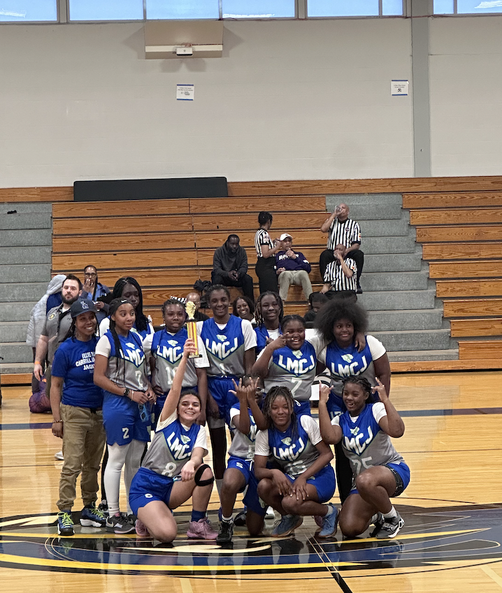 LMCJ Jaguars basketball team and coaches celebrating with a trophy