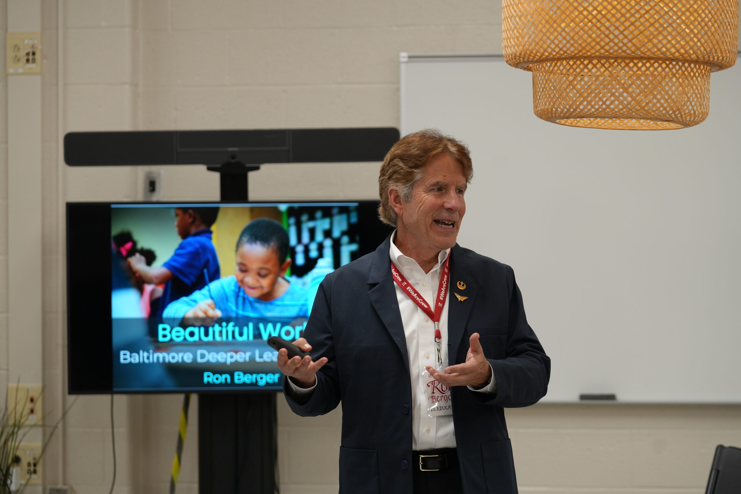 Ron Berger presenting beside a screen showing Beautiful Work at the Baltimore Deeper Learning gathering